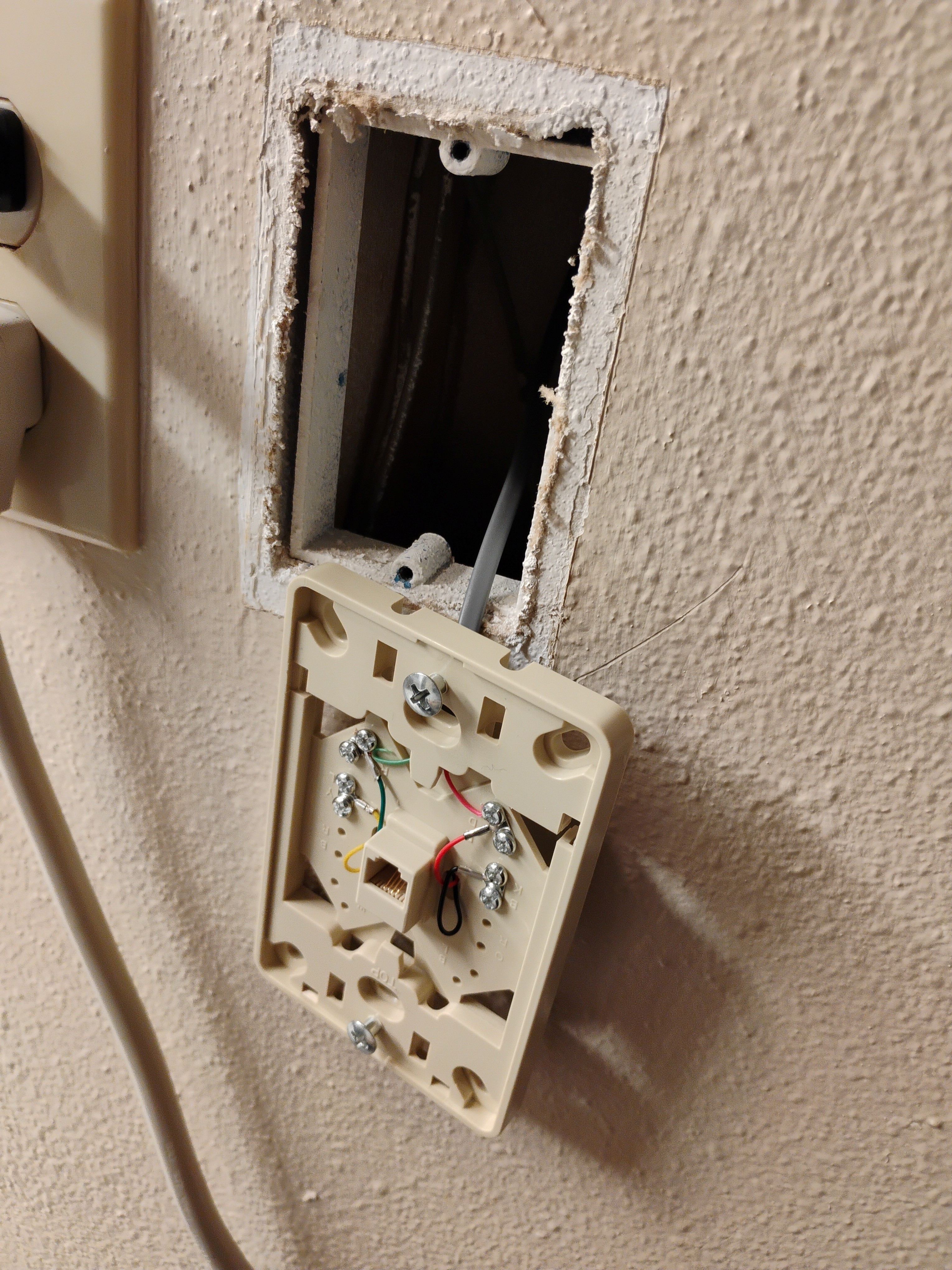 Phone mounting plate with the cable attached through the wall.