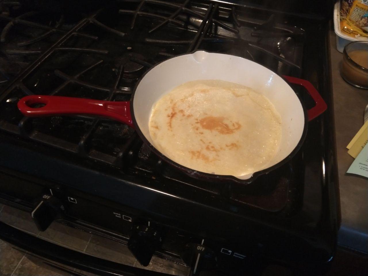 Crepe cooking on a skillet.