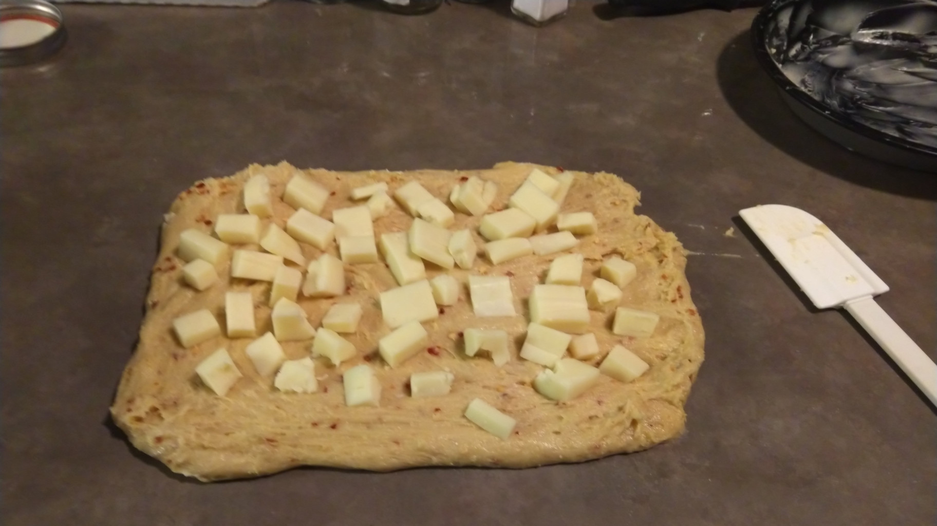 Dough spread out with cheese before rolling.