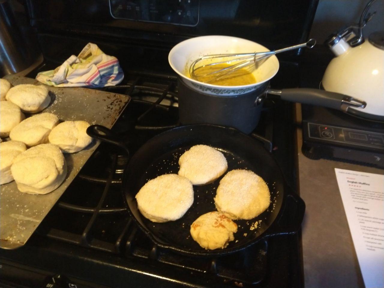 English muffins cooking in a cast iron skillet. English muffins cooking in a cast iron skillet.