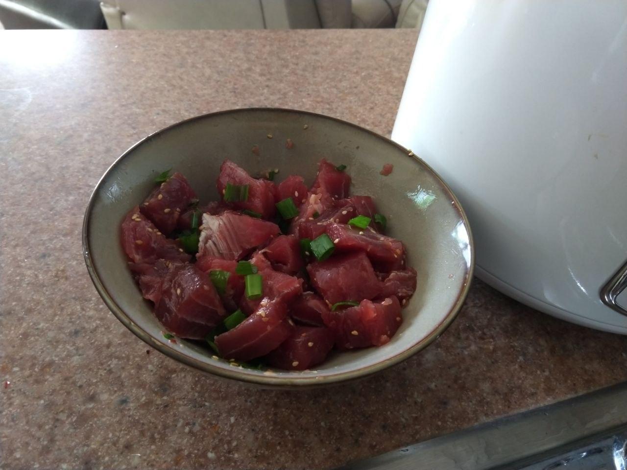 Bowl of Ahi Poke with green onions and sesame seeds.