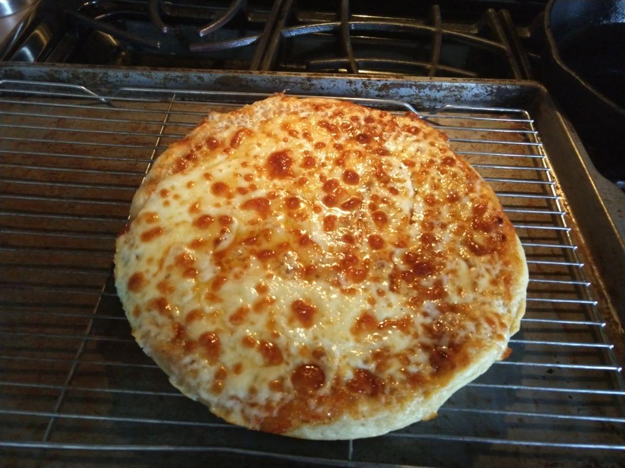 Finished pizza cooling on a rack.