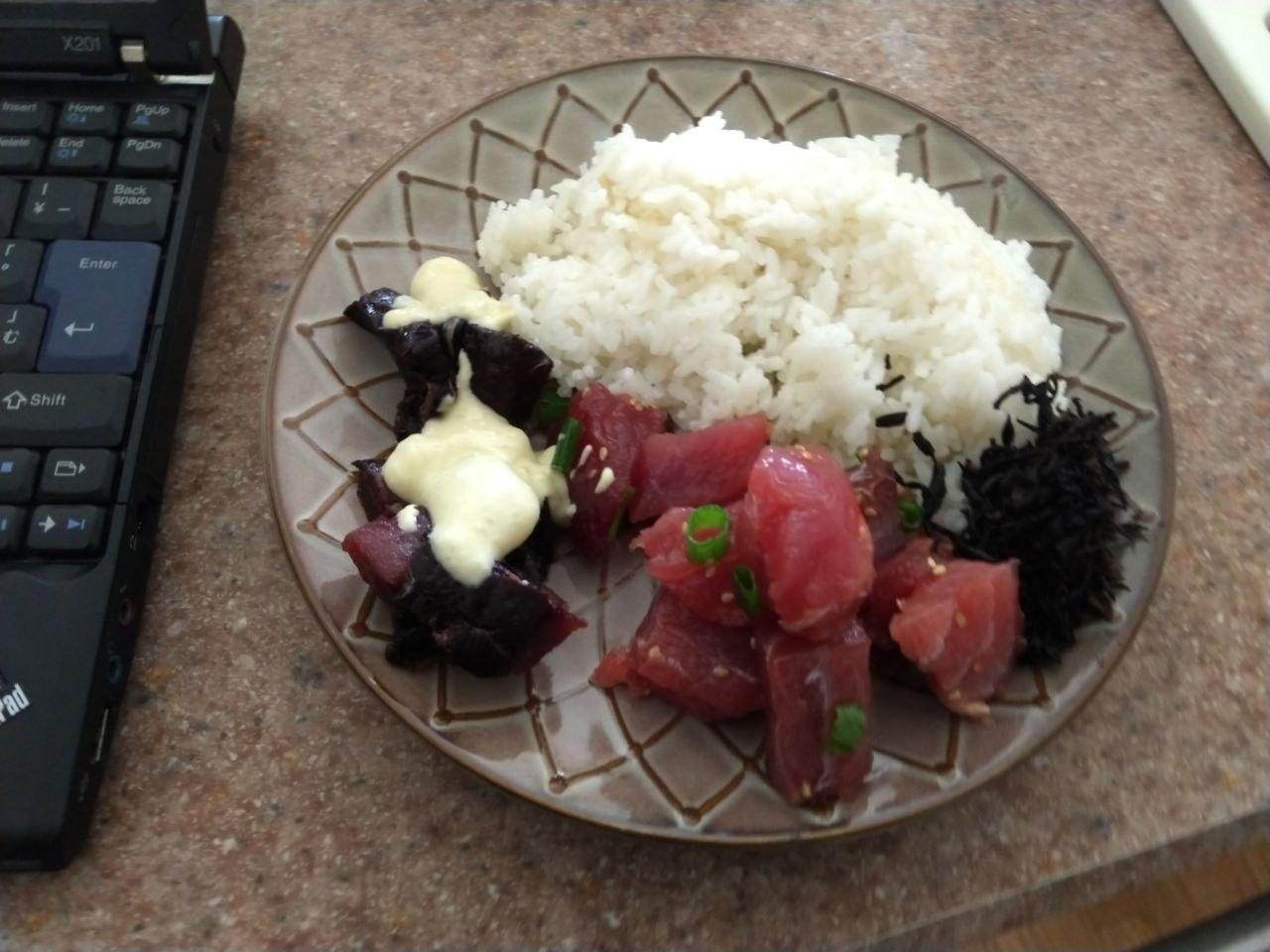 Plate of Ahi Limu Poke with rice and spicy poke sauce.