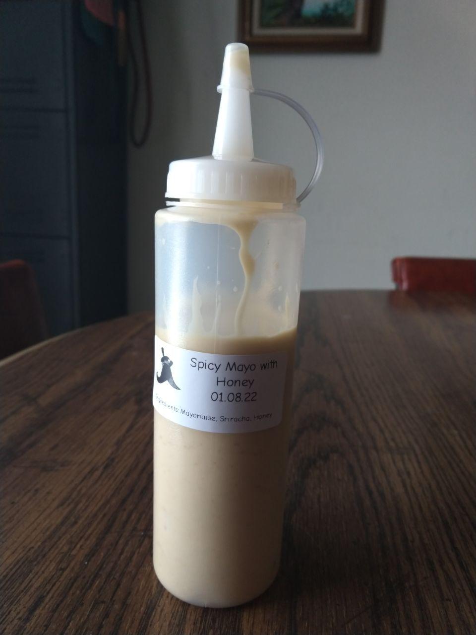 Bottle of spicy mayo made with homemade sriracha, mayonaise, and honey.