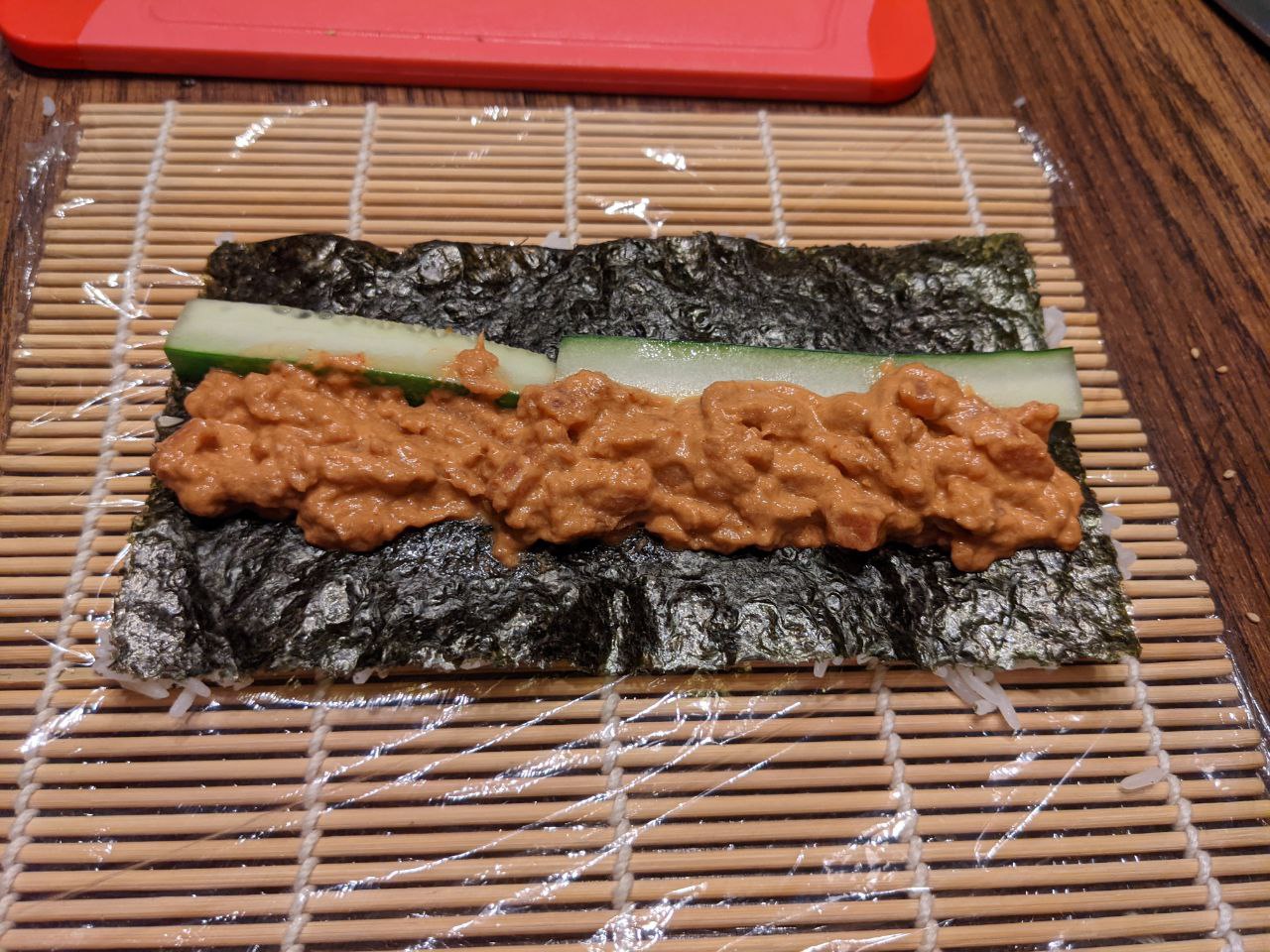 Rolling spicy tuna roll on bamboo mat. Rolling spicy tuna roll on bamboo mat.