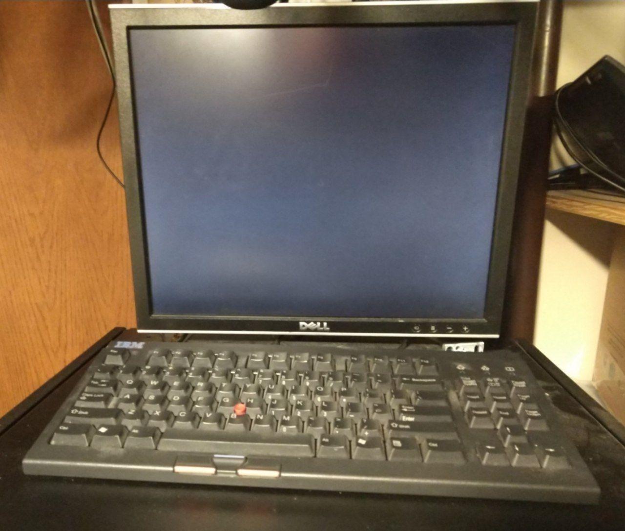 An IBM SpaceSaver II keyboard on top of my server rack, with a monitor.